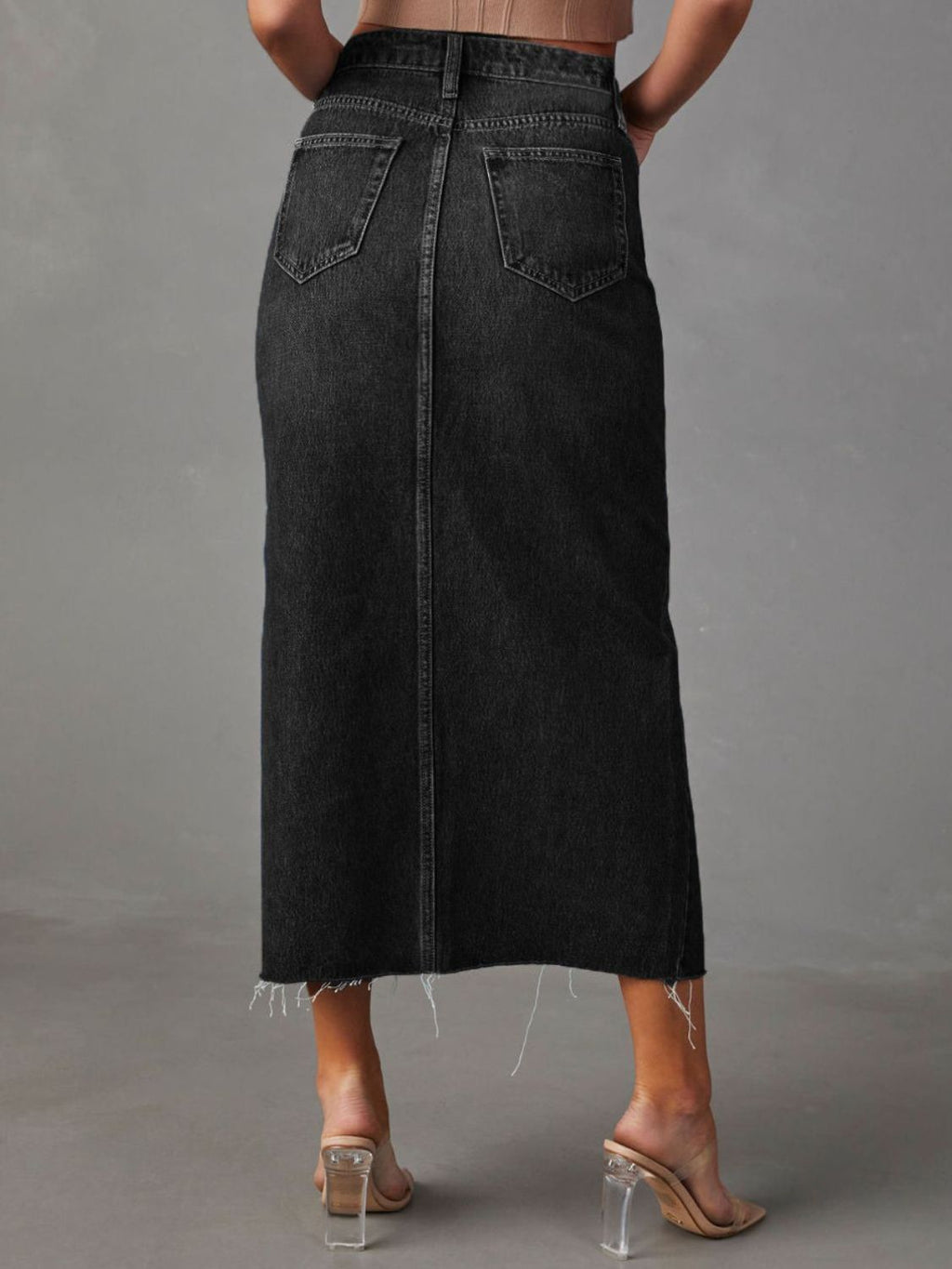"Raw hem front slit denim midi skirt with a trendy, edgy look. Features a front slit for movement, and a raw hem for a chic, unfinished style."