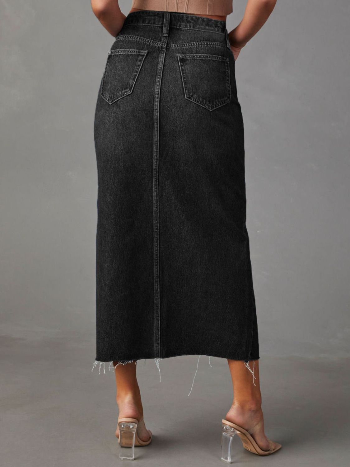 "Raw hem front slit denim midi skirt with a trendy, edgy look. Features a front slit for movement, and a raw hem for a chic, unfinished style."