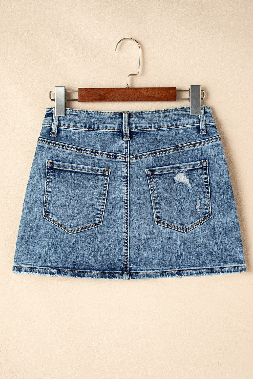"Trendy rhinestone distressed denim mini skirt with edgy distressed detailing, sparkling rhinestones, and a flattering fit, perfect for a chic, casual look"