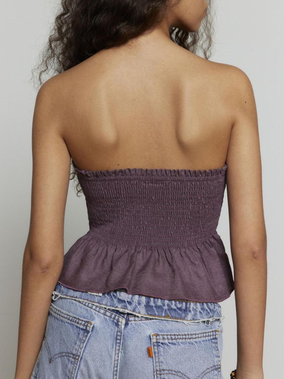 "Woman wearing ruffled tube top with layered detail, perfect for summer outfits and casual chic style"