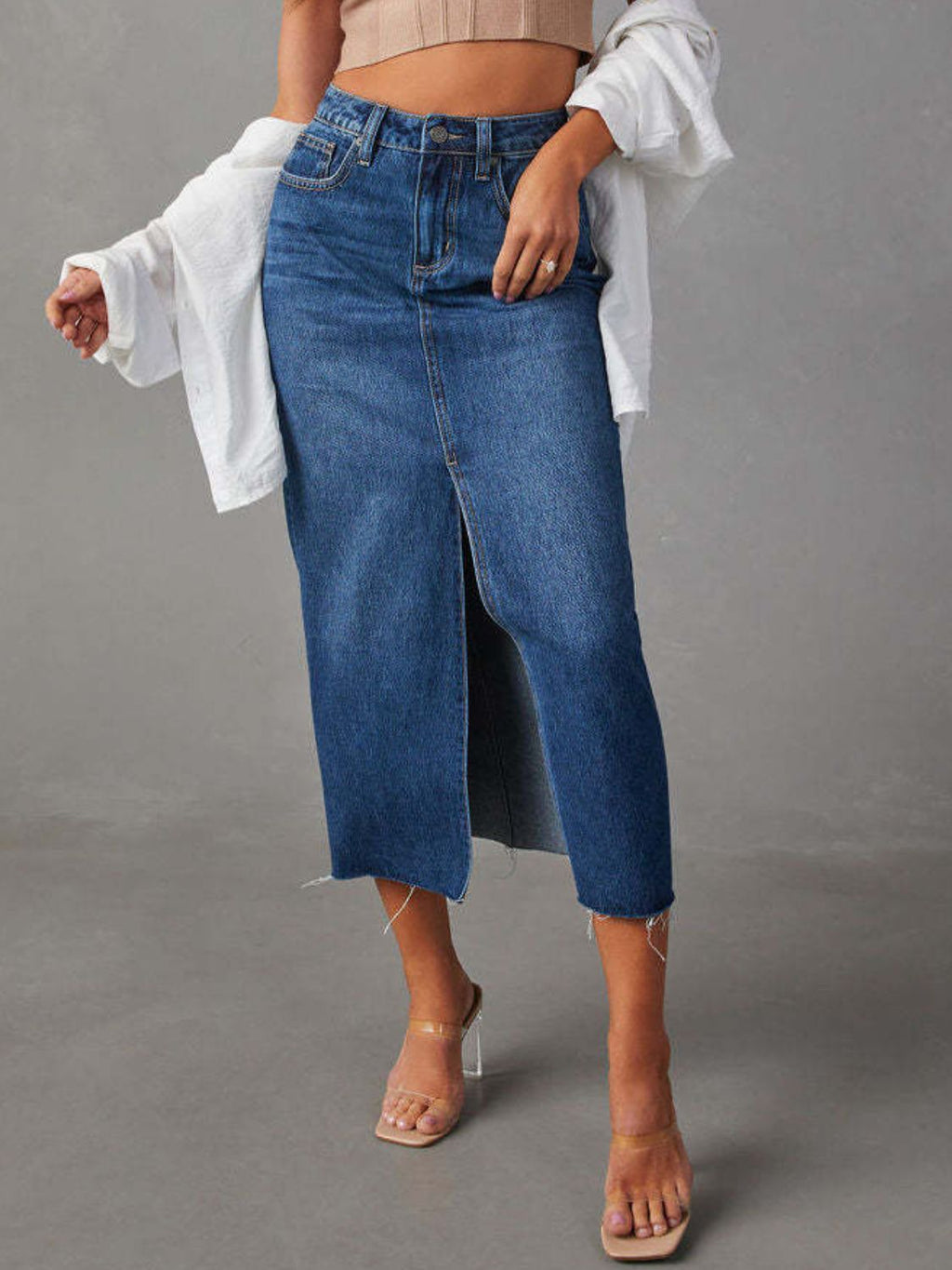 "Raw hem front slit denim midi skirt with a trendy, edgy look. Features a front slit for movement, and a raw hem for a chic, unfinished style."