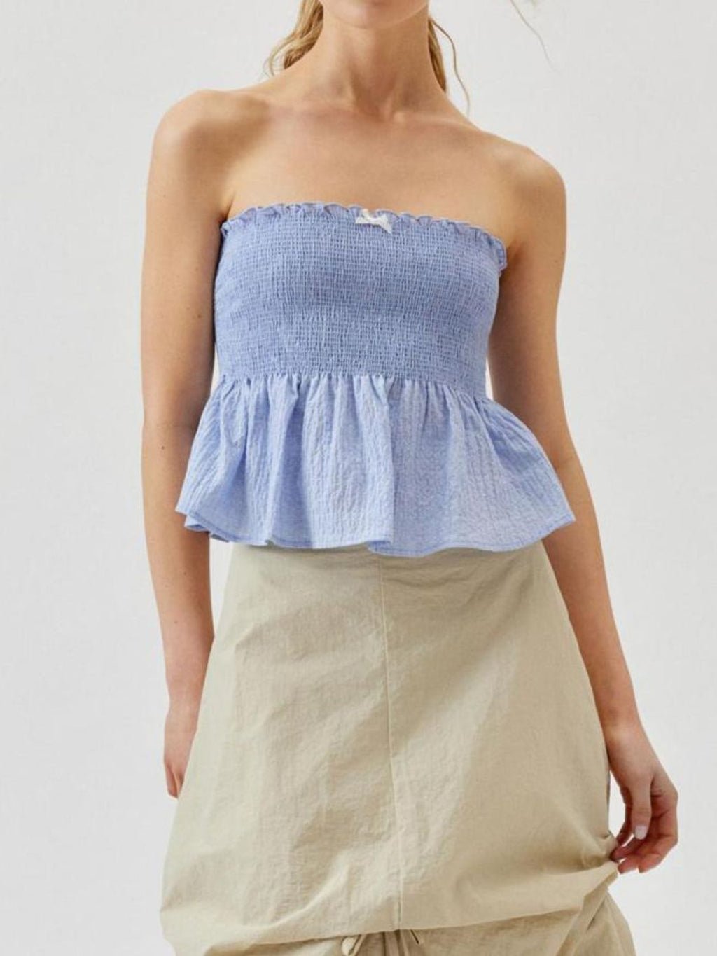 "Woman wearing ruffled tube top with layered detail, perfect for summer outfits and casual chic style"