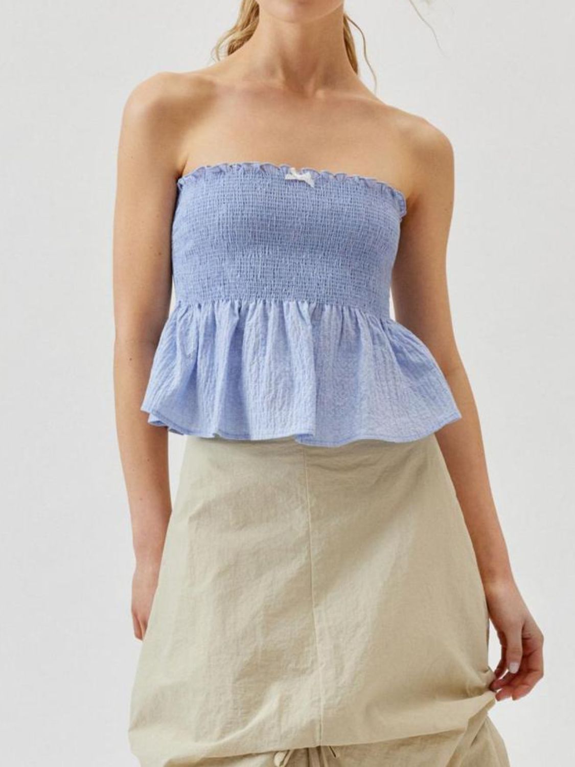 "Woman wearing ruffled tube top with layered detail, perfect for summer outfits and casual chic style"