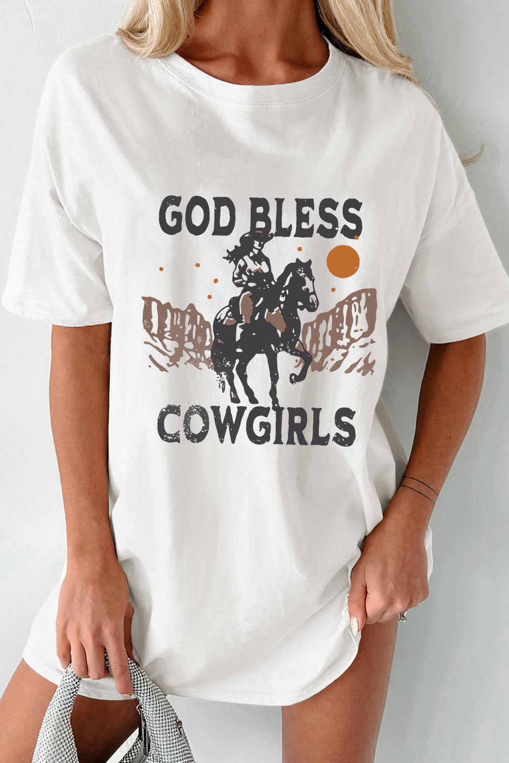 "God Bless Cowgirls Tee – Western-inspired graphic t-shirt celebrating strong and fearless cowgirls with country charm."