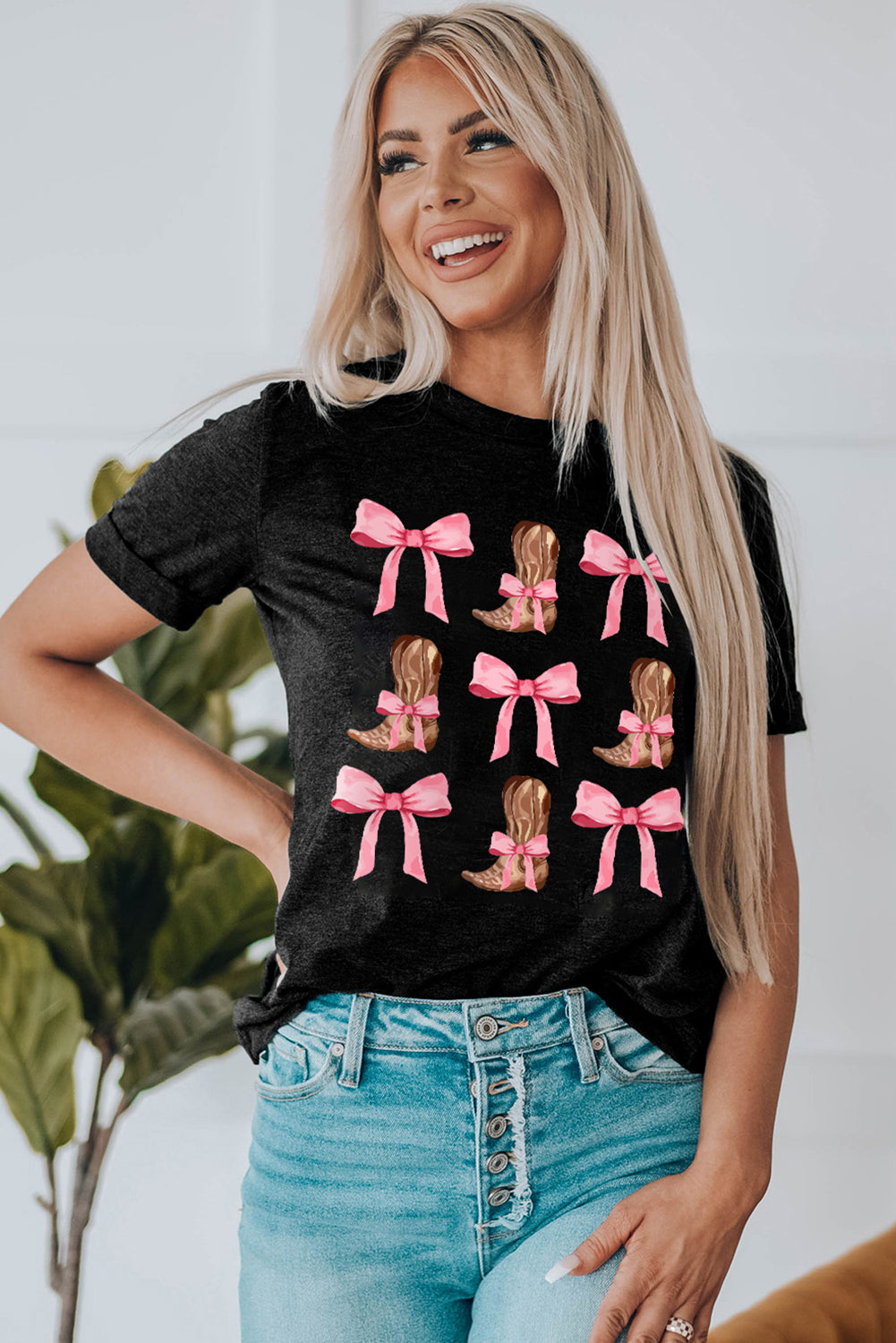 "Woman wearing Bow & Boot graphic tee with western boots and casual denim for a trendy country look"