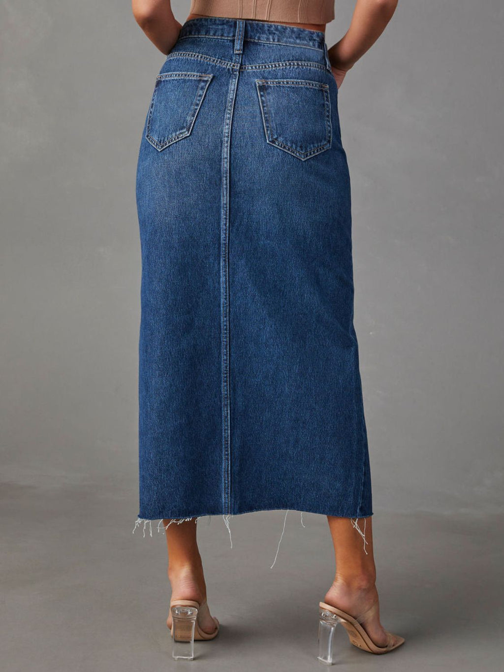 "Raw hem front slit denim midi skirt with a trendy, edgy look. Features a front slit for movement, and a raw hem for a chic, unfinished style."
