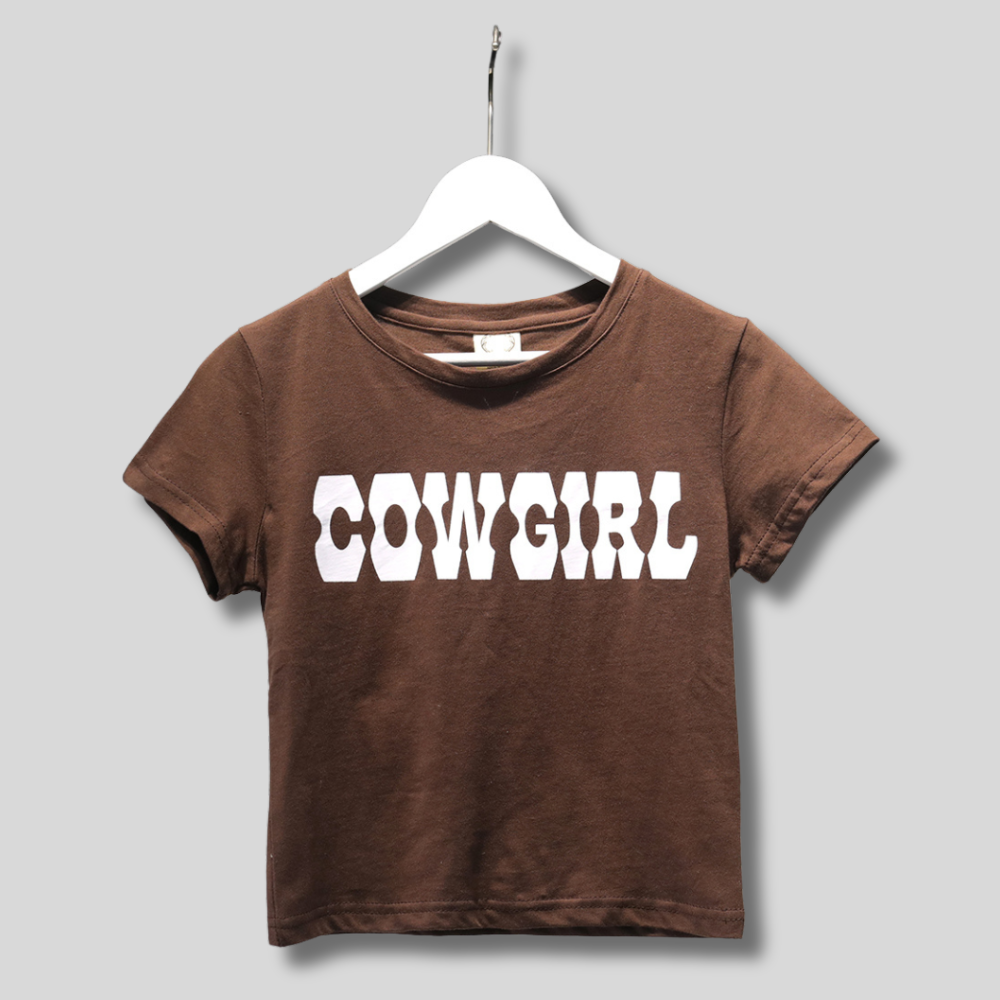 Brown cowgirl crop top with bold white lettering, short sleeves, and a trendy relaxed fit. Western-inspired casual fashion.